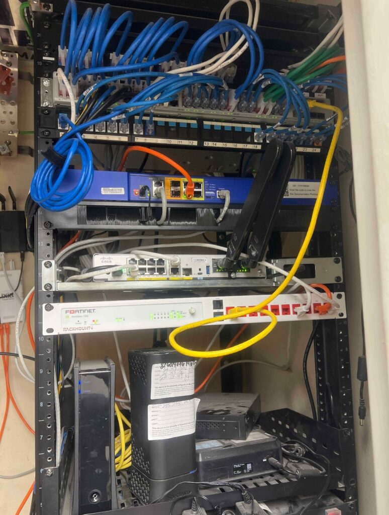 Onsite IT support reviewing network infrastructure, cabling, and equipment for a medical or dental practice