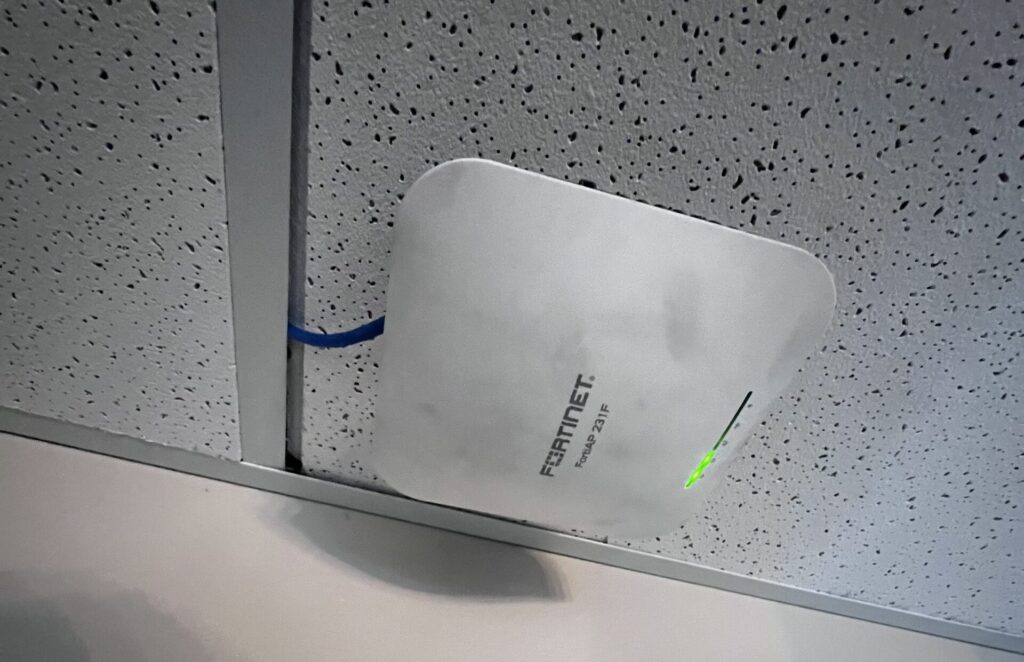 Ceiling-mounted wireless access point connected to network infrastructure after office layout changes